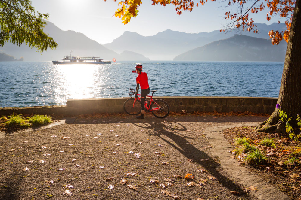 One male cyclist taking a photo on the shore of Lake Lucerne in Kanton Luzern, Switzerland